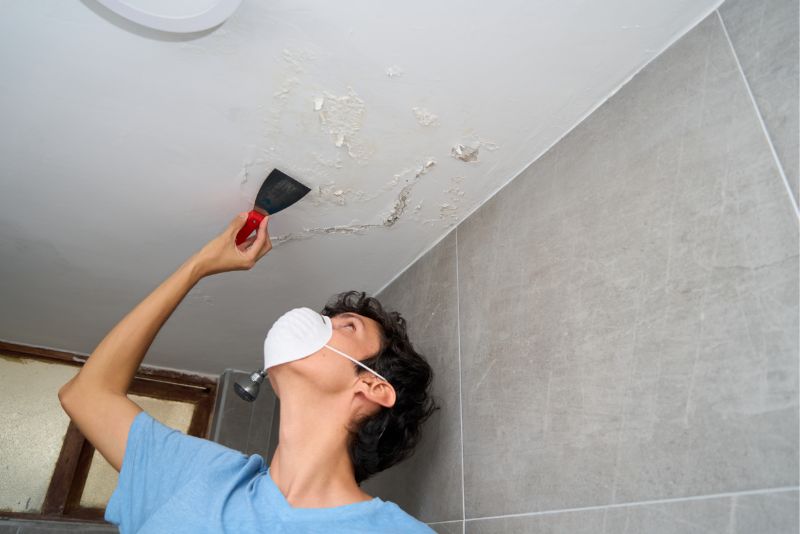 worker doing repairs on ceiling after mould removal