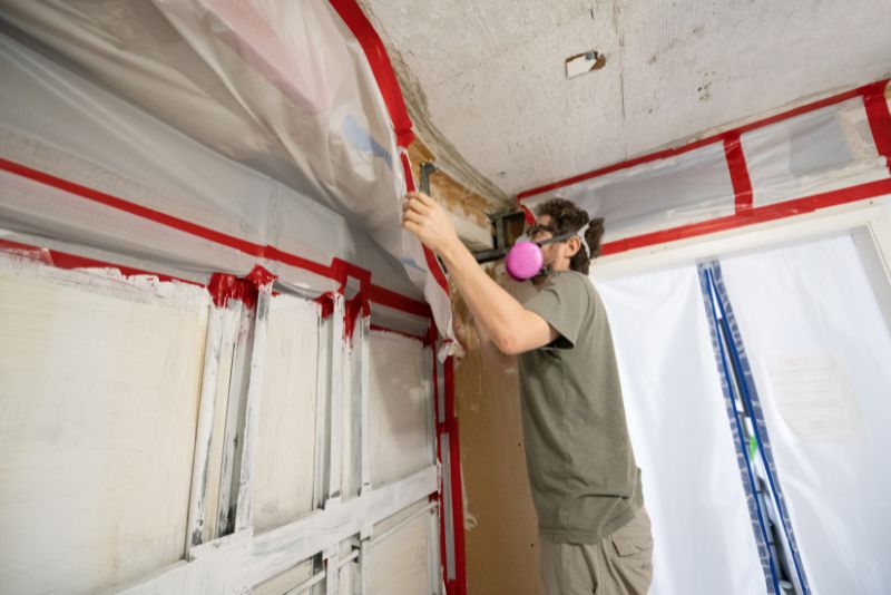 worker making sure the house under construction is mould proof
